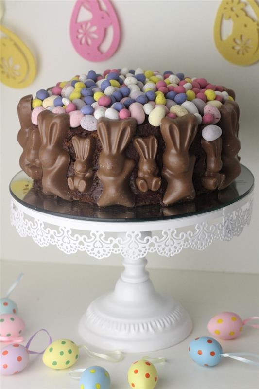 enkel choklad påsk tårta dekorerad med mini påskägg och skiktade chokladkaniner som går runt kakan