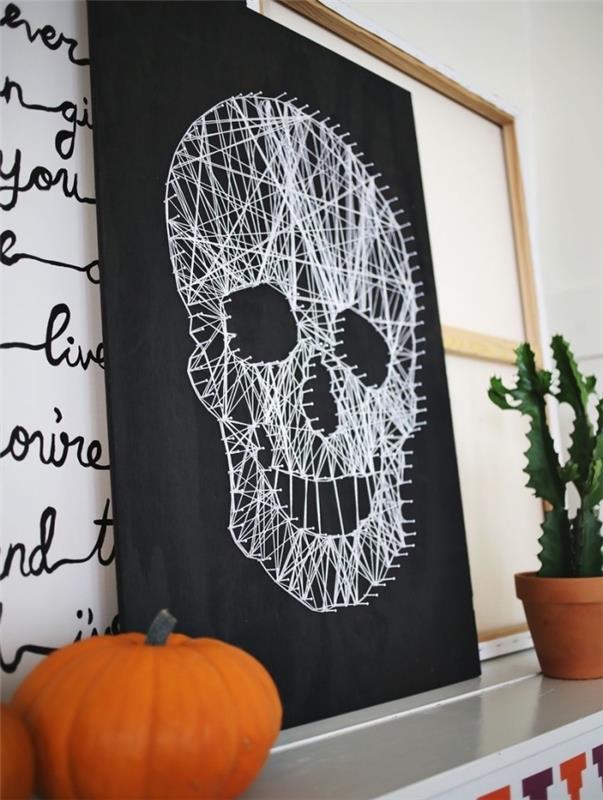 ukážka DIY halloweenskej dekorácie s tabuľou v tvare lebky a malej oranžovej tekvice