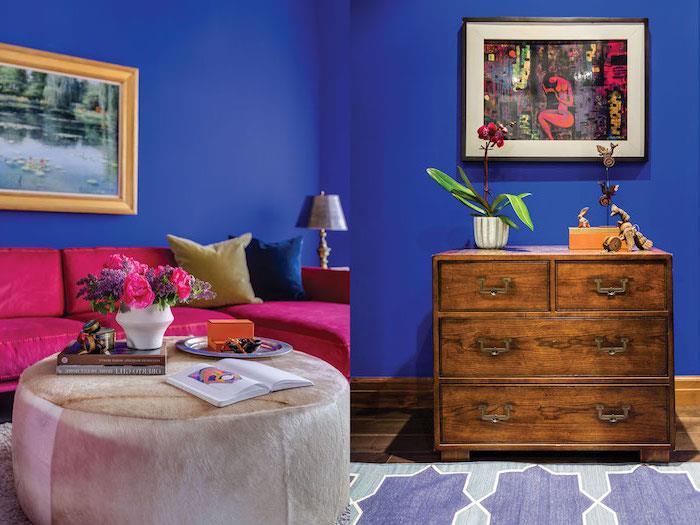 väggmålning, vardagsrum med mörkblå målade väggar, hallonfärgad sammetsoffa, fotoram i gyllene nyans
