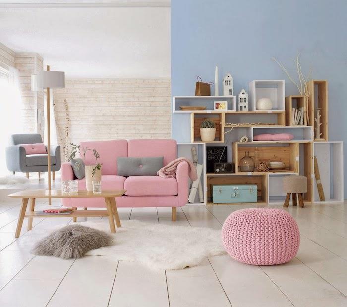 vardagsrum med blå och vita väggar, mjuk vit matta och brun fuskpälskudde, litet lågt vardagsrumsbord i trä