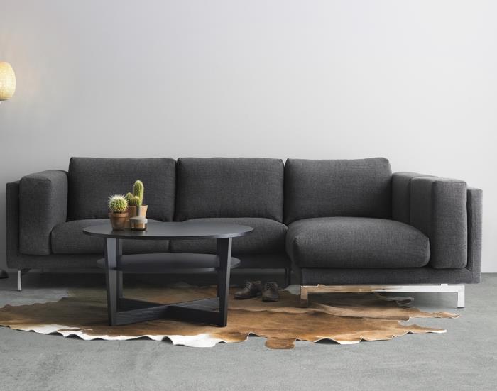 bekväm soffmodell i mörkgrå kombinerat med ett runt bord i mattgråa, gråa vardagsrumsmöbler