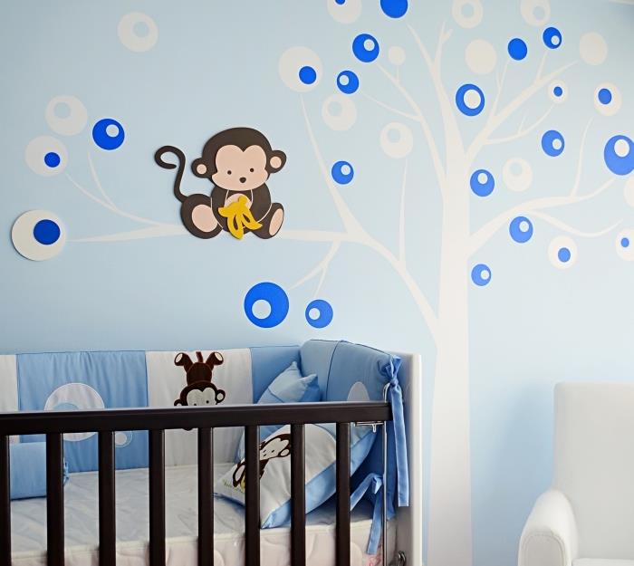 nápad, ako vyzdobiť steny v miestnosti pre novorodencov modrou farbou na stenu a ozdobnými nálepkami s dizajnom stromu s opicou