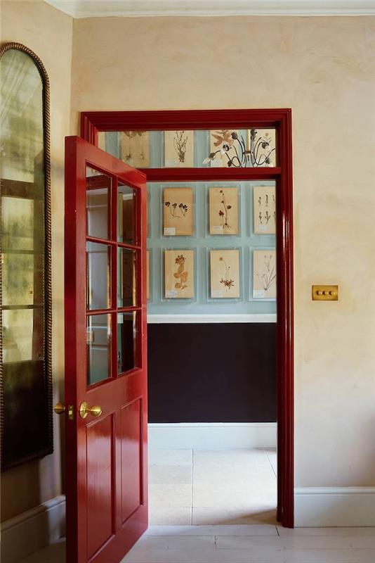 dörrdekoration i glänsande röd färg med glaselement som ger till korridoren