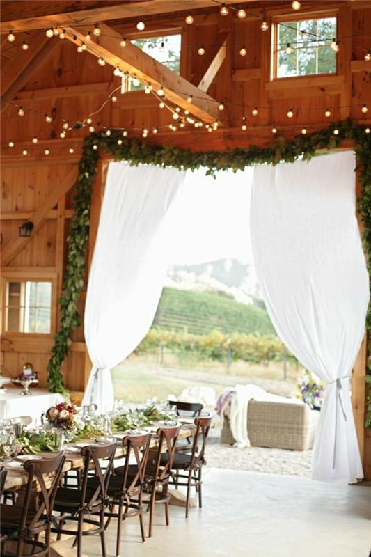 billigt-bröllop-rum-dekoration-med-gröna-grenar-och-ljus-kransar