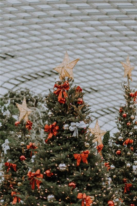 Fotografia vianočného stromčeka ozdobená červenou stuhou a metalickými guľkami, nápad, ako ozdobiť vianočný stromček v červenej a zlatej farbe