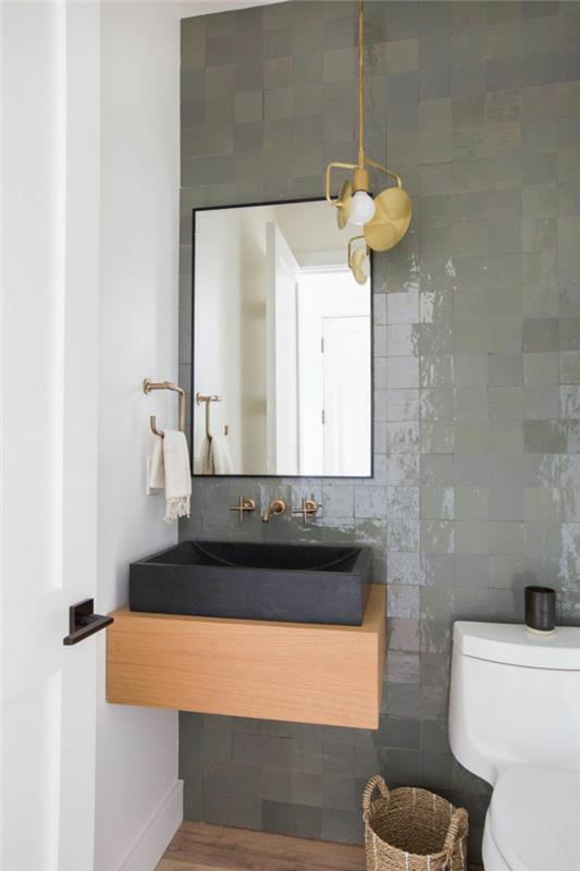 svetlosivé obklady do WC, drevená skrinka pod umývadlo a čierne umývadlo, zrkadlo obdĺžnikové, tkaný košík