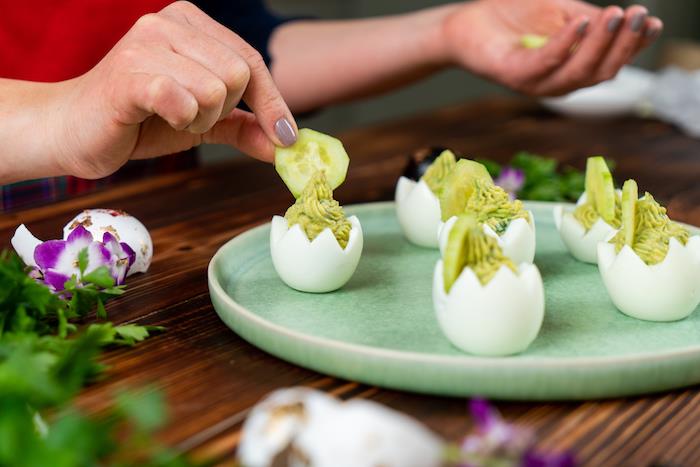 dekorera med en skiva gurka toppen av ett mimosa ägg fylld med äggula, senap, avokado, idé till en original påsk kall förrätt