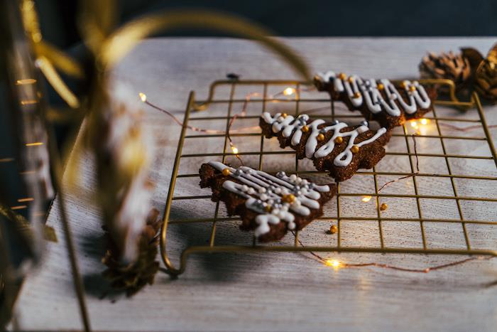 pepparkakor med kunglig glasyrdekoration och gyllene ätbara pärlor, julkakadekoration