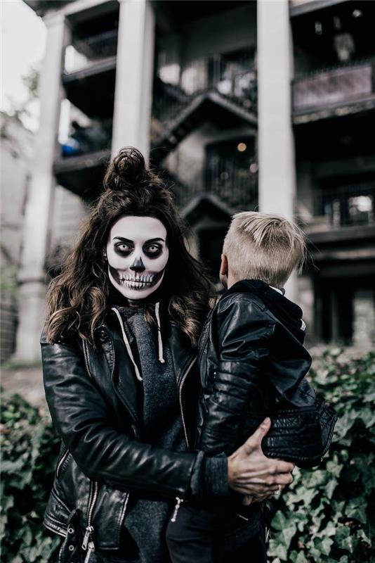 zábavný pár kostým desivý makeup čierne oblečenie kostra makeup matka a syn pred budovou