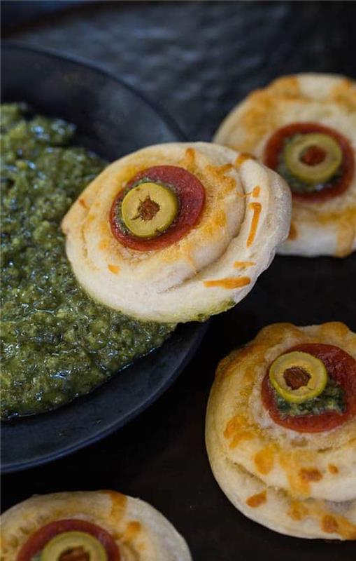 očné gule na malých pizzách preliate halloweenskou toastovou pesto omáčkou