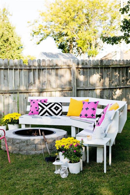 príklad, ako zariadiť svoju záhradu ohňom a bielou drevenou lavičkou na trávniku, modely farebných dekoratívnych vankúšov