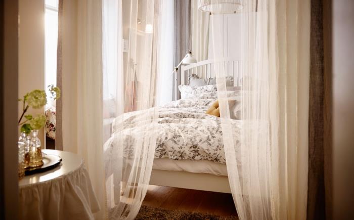 romantisk atmosfär i sovrummet med beige segel och vit träramssäng, inredning av trägolvet med mjuk brun matta