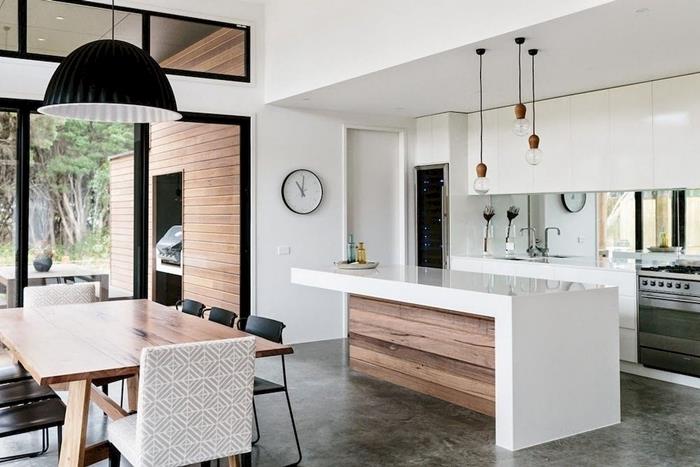 interiérový dizajn otvorená moderne vybavená kuchyňa s bielym ostrovom a drevenou závesnou lampou