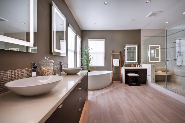 moderná drevená a sivá kúpeľňa, dekorácia kúpeľne so sivými stenami s podlahou zo svetlého dreva a vaňou na mozaikových dlaždiciach