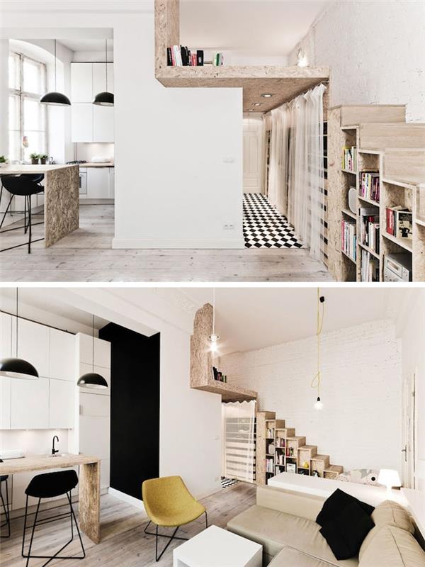 studiolayout med trätrappa med förvaring under trappan, svartvitt köksinredning med svarta upphängningar ovanför ett centralt träbord, beige soffa