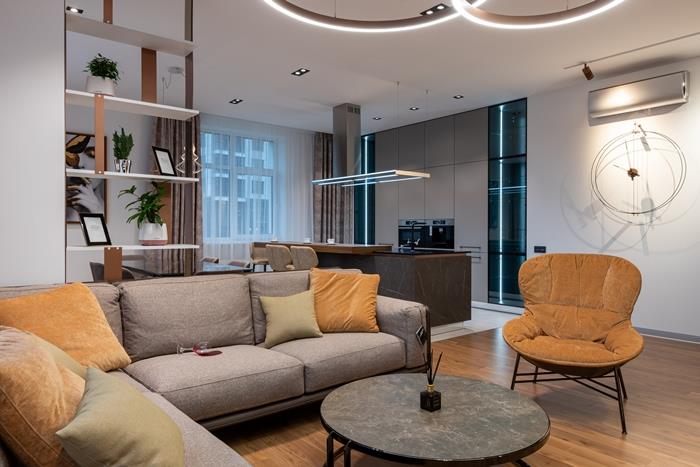 moderný štýl interiérový dizajn obývacia izba drevené parkety ťava kreslo šedá sedačka dekoračné vankúše