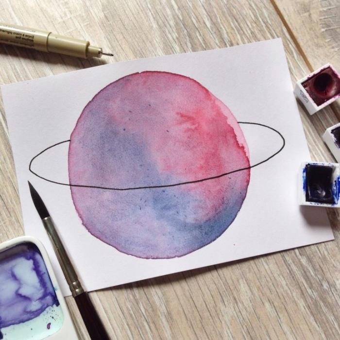 ganska rosa-lila planet i akvarell med sin ring gjord med svart filt, lätt att måla att lära sig akvarell