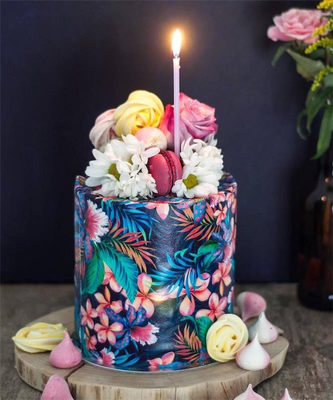 tropisk födelsedagstårtedesign, blommönster och palmträdsmönster på svart bakgrund och toppdekoration med färska blommor och makroner