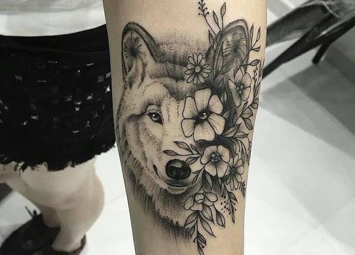 žena s tetovaním vlka, vlčia hlava s kvetmi na ruke, ženský model kresliaci tušom