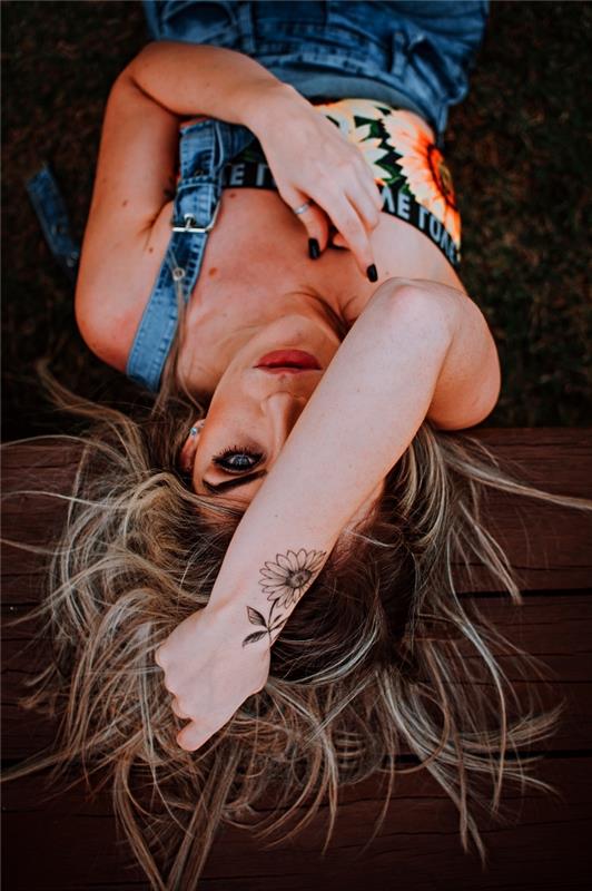 pekná slnečnicová kvetina vytetovaná na zápästí, diskrétna žena, nápad na tetovanie zápästia, kvetinové tetovanie na paži