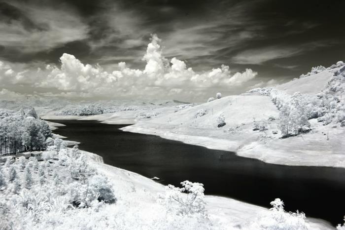 landskap bakgrund, vackert landskap, en flod på vintern, vita moln på bakgrunden av en mörkgrå himmel, svartvitt foto