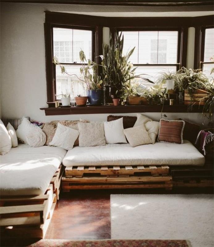 Idea divani in palet con schienale basso, tanti cuscini di colore chiaro per conferire confort