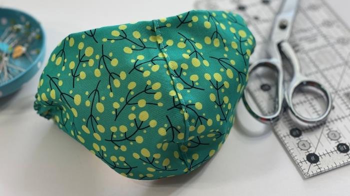 hemlagad ansiktsskyddsmask modell, exempel på en coronavirusmask i grönt tyg med ficka och resår