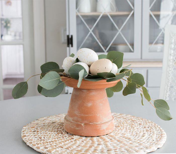 diy veľkonočné ručné činnosti jarný deco stôl v obrátenom a bielenom kvetináči a bledých farbách veľkonočných vajíčok
