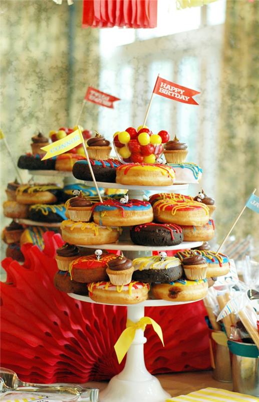 croquembouche malých koláčov poukladaných na biely prezentačný podnos, červený vejár