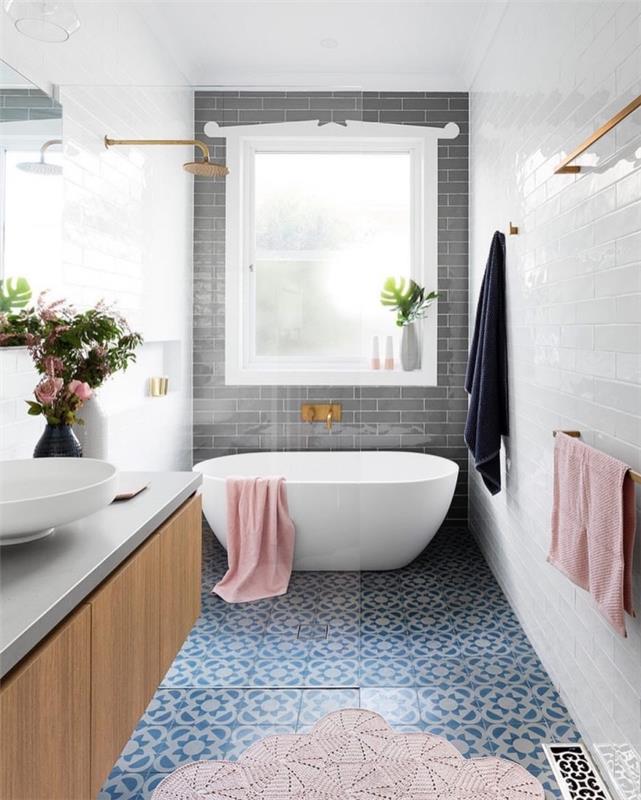 dlaždice vzhľadu modrej sedmokrásky so vzorom cementu v tejto modernej kúpeľni sú spárované s bielymi a sivými dlaždicami metra