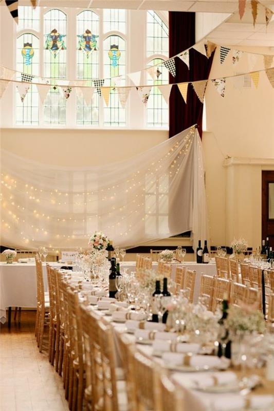 bröllop-tak-drapera-i-vitt-bröllop-dekoration-med-ljus-krans-stora-rektangulära bord
