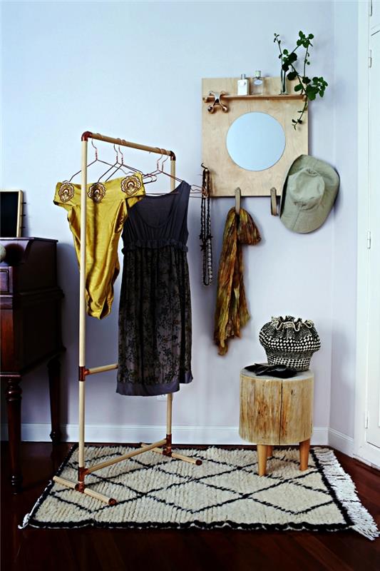 omklädningsrum med diy klädhängare i träpinnar och koppararmbågar, öppet omklädningsrum med klädställ, träpall och liten hylla med spegel