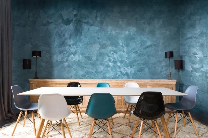 trendová modrá farba v modernom interiéri, výzdoba jedálne s modrými stenami s pieskovou textúrou a bielym stolom