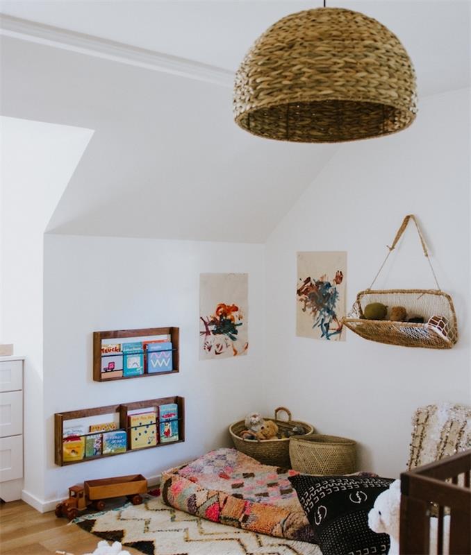 matbord i trä med barnböcker och färgade madrasser på golvet dekorativa kuddar korgar förvaringsutrymme för lek och originalläsning