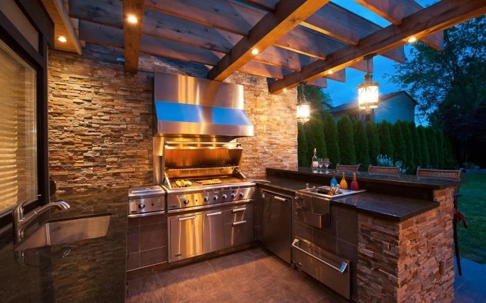 nápad na vonkajší kuchynský prístrešok s drevenou strechou a led osvetlením, letná kuchyňa s kamennými múrmi osadená v U