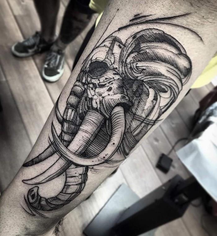 elefantskalle, underarmstatuering, trägolv, tatueringsdesign för män