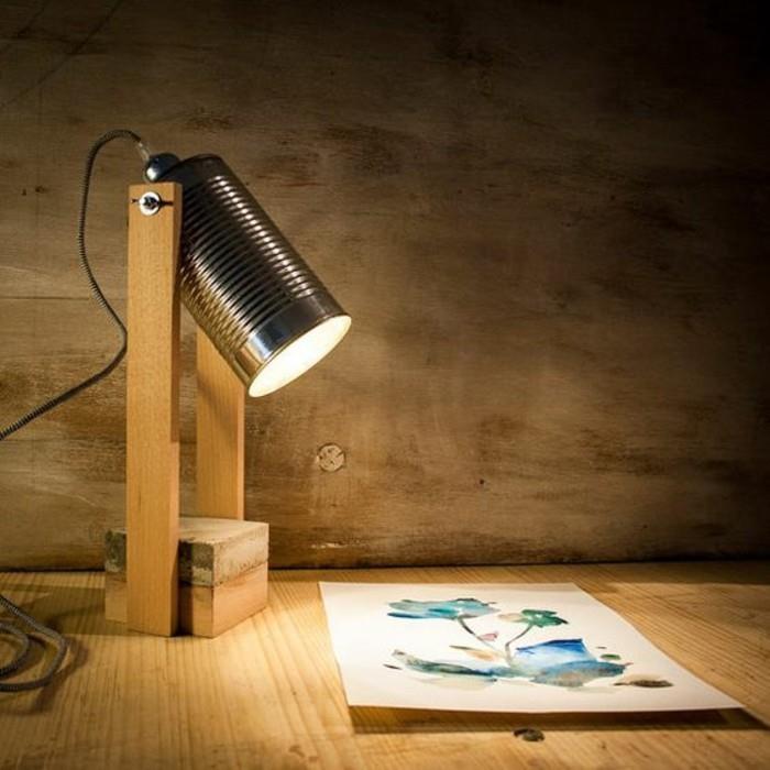 projektorliknande skrivbordslampa, lampa av trä och en plåtburk som belyser en akvarellritning
