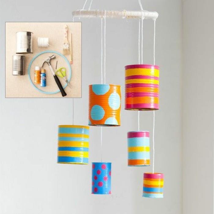 dekoration gjord av sex burkar i olika färger, dekorerad med färg i olika färger, med former och ränder, hängande på vit tråd