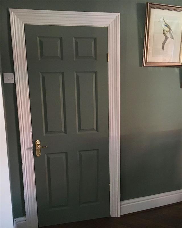 dörrkarm i annan färg vit karm och en dörr och vägg i reseda