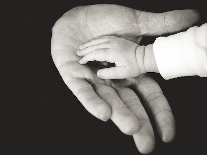Babyens hand i hans mors hand, vackra bilder för mors dag, lycklig mors dag, svartvitt fotografi