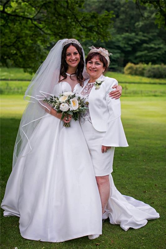brudens mor uppsättning av vit knälång klänning och matchande utsvängd ärmjacka