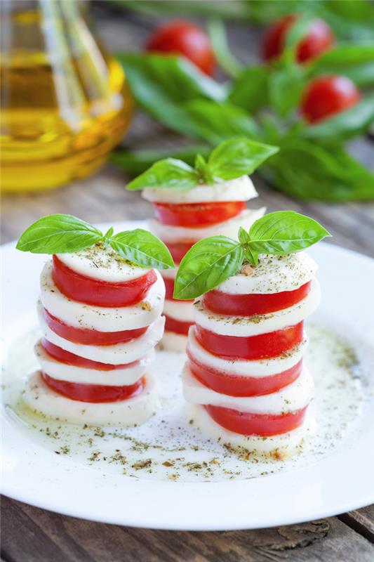 nápad na šalát caprese v plátkoch mozzarelly a paradajok s bazalkou, originálny taliansky aperitívový šalát