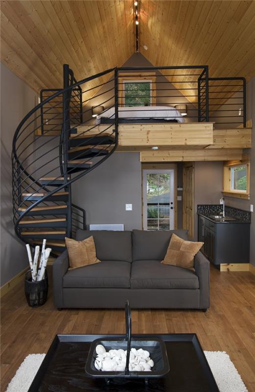točité schodisko, podkrovná spálňa, sivá sedačka, praktická kuchyňa a obývačka