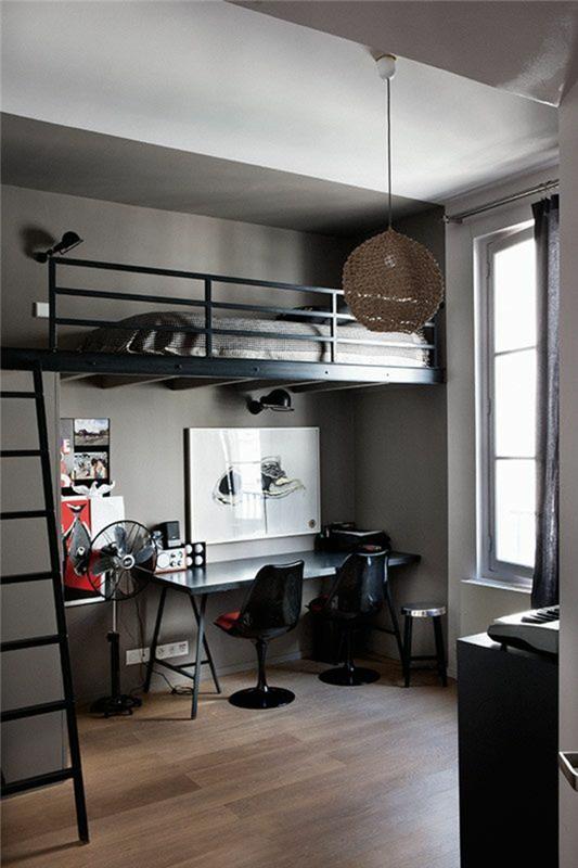 taupe parkett, vitt tak, säng med svart metallräcke, svart stege, överlagrat ovanför skrivbordet, student sovrumsinredning, två svarta stolar, bollampa i beige trådar