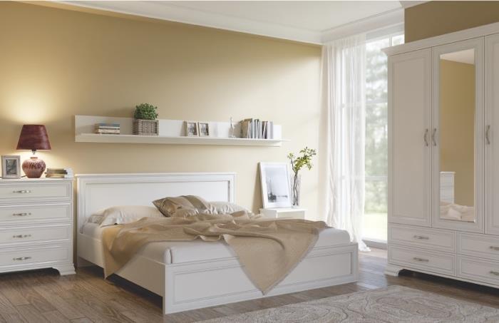 beige och vita sovrumsmöbler i trä, stor sängmodell med sänggavel och trästomme och vitt läder, vit horisontell hylla med böcker och grön växt