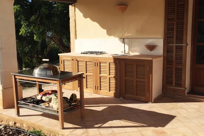 príklad vonkajšej drevenej kuchyne s plynovým faucetom a planchou, záhradná kuchynská skrinka s drevenými skrinkami