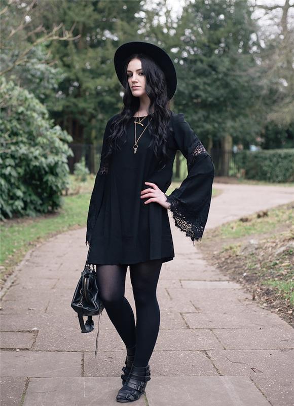 svart klänning med utsvängda ärmar med spetseffekt, svart hatt, trendig svart handväska och guldhalsband