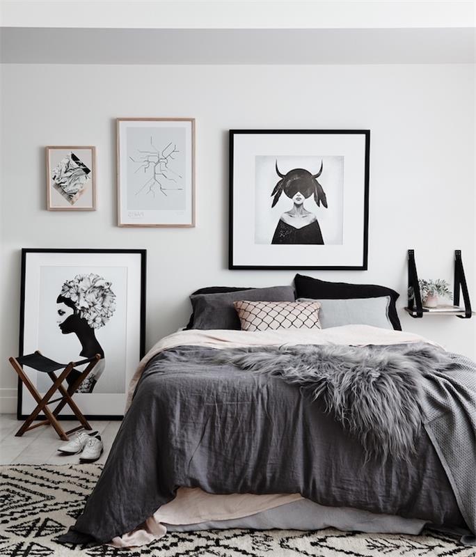 exempel på en skandinavisk sänggavel, grå och ljusrosa sängkläder, svartvit matta, svartvitt ramdekoration på en vit vägg
