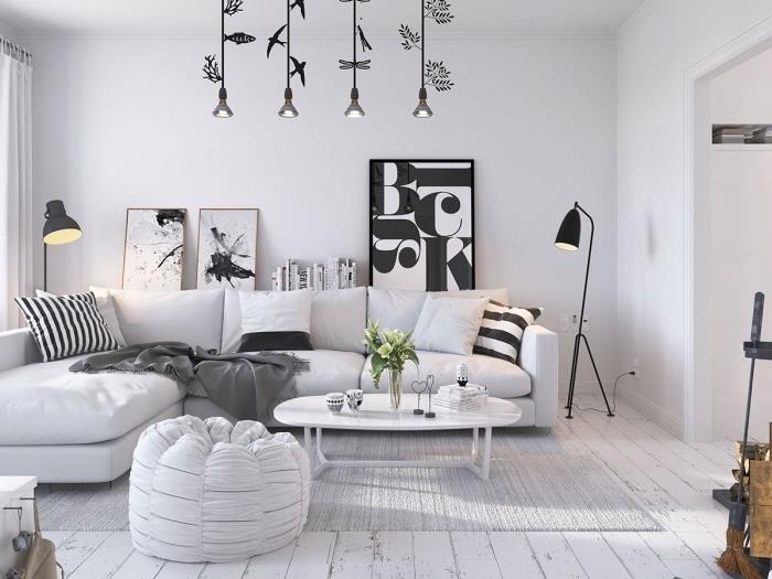 nápad, ako vyzdobiť škandinávsku obývačku, sivý koberec, bielu sedačku s čiernobielymi ozdobnými vankúšmi, grafické ozdobné panely, originálne závesné svetlá