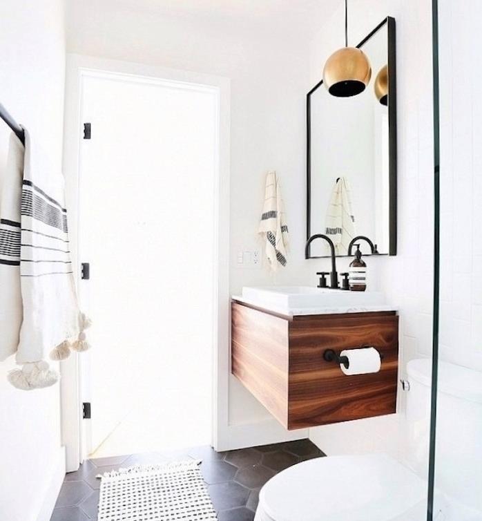 dispozícia kúpeľne vchod malý nábytok pod zavesenú umývadlo, obdĺžnikové zrkadlo, sivá dlažba, biele wc